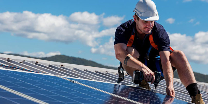 Technician installing rooftop solar panels
